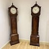 georgian-longcase-clock-handley-moore-london -showroom image of two very similar georgian london longcase clock with convex painted round dial and fine quality mahogany cases.