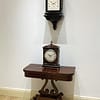 london-georgian-single-pad-top-fusee-bracket-table-clock-showroom image of the georgian clock in a showroom setting above a regency card table