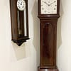 recordon-london-georgian-mahogany-longcase-grandfather-clock-showroom-view Image of the flame mahoagny georgian longcase clock next a walnut wall regulator in Story Antique Clocks showroom