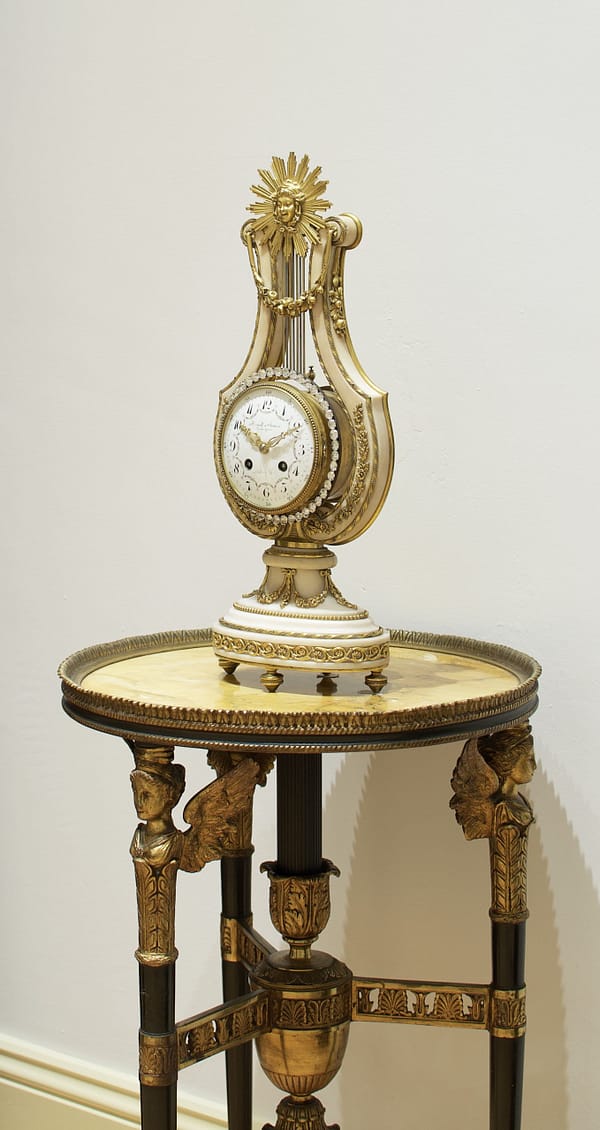 french-white-marble-lyre-mantel-clock-detail a side view image of the impressive antique lyre mantel clock shown on a sienna marble gueridon